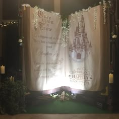 an image of a disney castle themed wedding ceremony backdrop with candles and flowers on the floor