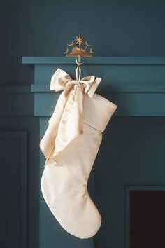 a christmas stocking hanging on a fireplace mantel with a gold star ornament