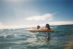 two people on a surfboard in the ocean