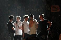 the group of young men are standing together in front of an audience at a concert