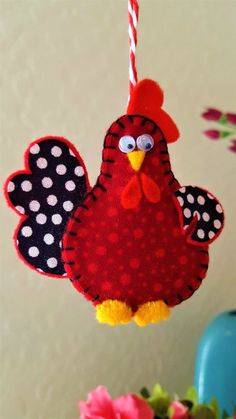 a red and black bird ornament hanging from a string with polka dots on it