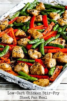 a sheet pan filled with chicken and veggies covered in seasoning next to a wooden table