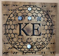 a wooden plaque with the letter k e on it