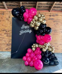 a happy birthday sign made out of balloons and black, pink, gold and white balloons