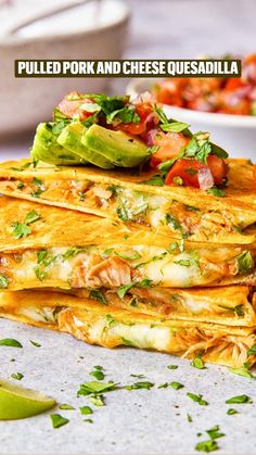 several quesadillas stacked on top of each other with salsa in the background