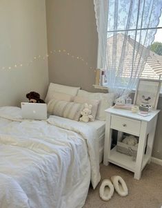 a white bed sitting next to a window in a room with lights on the walls