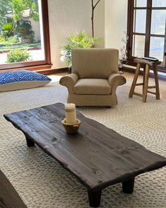 a living room with two chairs and a coffee table in the middle on carpeted flooring