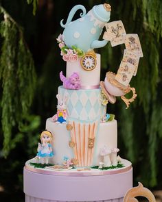 a three tiered cake decorated with figurines and other decorations on top of it