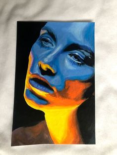 a painting of a woman's face with blue and yellow paint on it, against a white background