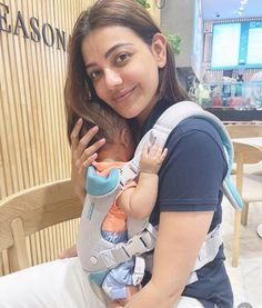 a woman sitting in a chair holding a baby