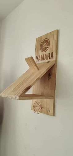 a wooden object hanging from the side of a wall with words that read yamaha on it