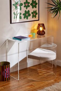 a white chair sitting in front of a table with a lamp on top of it