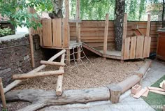 an outdoor play area with wooden structures and trees