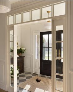 an open door leading into a room with black and white checkered flooring