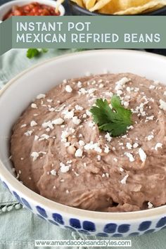 mexican refried beans in a bowl with chips and cilantro on the side