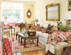 a living room filled with lots of furniture and flowers in vases on the table