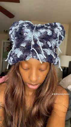 a woman with long hair wearing a blue and white crocheted beanie hat