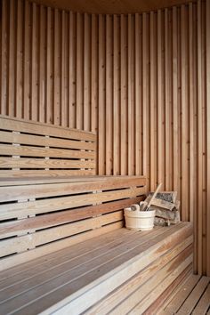 a sauna with wooden slats and buckets on the bench next to it