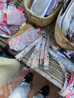 several purses are laid out on the ground next to some baskets and other items