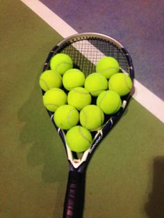 a tennis racket is filled with balls on the court as if it were just about to be hit