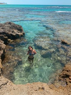 a woman is standing in the clear blue water