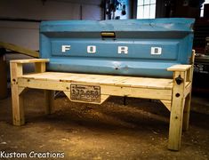 an old ford pickup truck bench made out of pallet wood with the word ford written on it