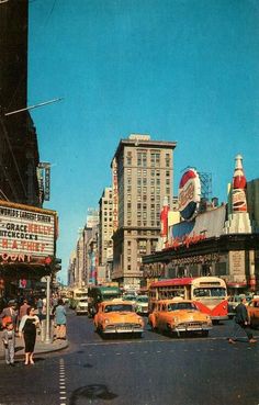 an old photo of cars and people on the street in front of some tall buildings