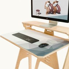 a computer monitor sitting on top of a wooden desk next to a keyboard and mouse