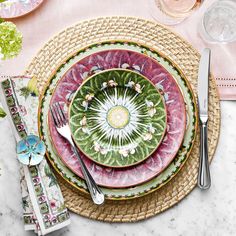 a place setting with plates, silverware and napkins on a marble table top