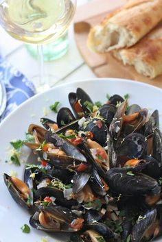 a white plate topped with mussels and garnished with parmesan cheese