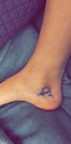 a woman's foot with a small tattoo on the top and bottom of it