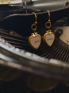 "* PLEASE NOTE: since these earrings are made to order from actual vintage book pages the text will appear slightly different with each set and may appear slightly off center due to its placement on the original page. The main italicized \"Jane Austen\" will remain the same, but any other partial letters below it will differ.  * Two small brass lockets, heart shaped. On the front is vintage paper that together reads, \"Jane Austen\". * No coating over the paper, so do not get wet.  * Raw brass l Jane Austen Jewelry, Jane Austen Inspired, Locket Earrings, Vintage Book Pages, Book Theme, Book Earrings, Book Gift, Earrings Heart, Gifts For Readers