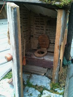 an outhouse with a toilet in it and moss growing on the roof, inside