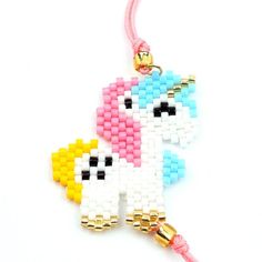 the beaded unicorn is hanging from a pink cord