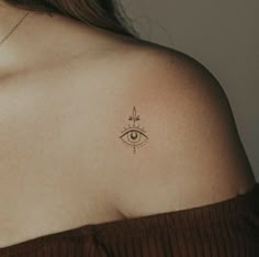 a woman's shoulder with an eye tattoo on it