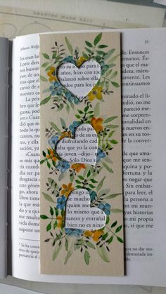 an open book with flowers and hearts on it