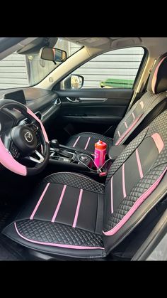 the interior of a car with pink and black leather trims, steering wheel cover and center console