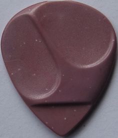 a pink guitar pick sitting on top of a white table