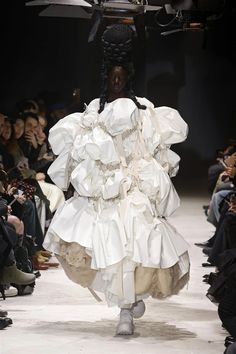 a model walks down the runway in a white dress with ruffles on it