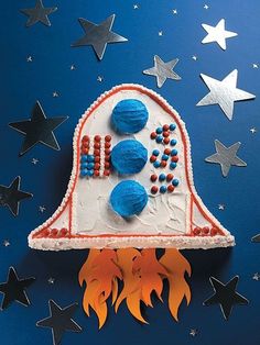 a cake shaped like a rocket ship with stars around it