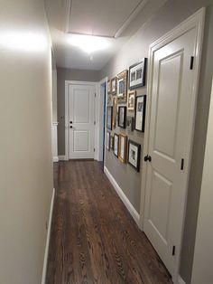 an image of a hallway with pictures on the wall and wood flooring in it