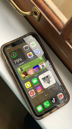 an iphone sitting on top of a white table next to a wooden drawer and mirror