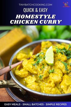 a bowl filled with chicken curry next to a wooden spoon and lime wedge on the side