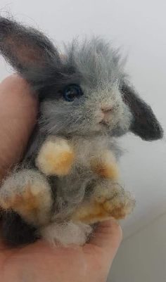 a small stuffed animal sitting in someone's hand