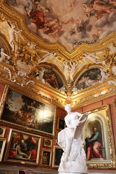 a statue is in the middle of a room with paintings on the walls and ceiling