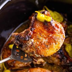 the meat is being cooked in the slow cooker with a spatula and yellow peppers