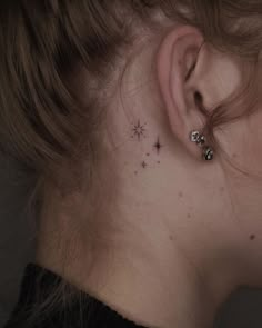 a woman's ear with small stars on it