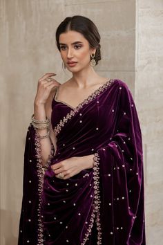 A photo of a Pakistani bridal saree in a rich purple velvet fabric. The saree is draped over a delicate, strappy blouse. There are minimal silver or crystal embellishments on the saree. Newly Married Saree Look, Velvet Saree Look, Pakistani Bridal Saree, Purple Saree Look, Saree 2022, Purple Velvet Fabric, Purple Sari, Pakistani Saree, Strappy Blouse