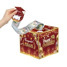 a hand is holding a gift box with money in it