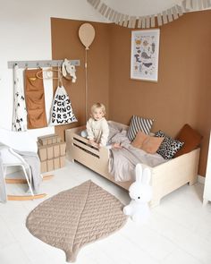 a small child sitting on top of a bed in a room filled with toys and decor